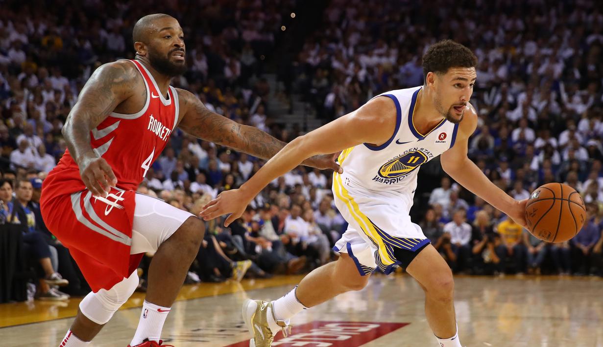 Pebasket Warriors, Klay Thompson #11 melewati adangan pebasket Houston, PJ Tucker #4 pada laga perdana NBA 2017 di Oracle Arena, Oakland, (17/10/2017).  Rockets menang 122-121. Rockets menang 122-121. (Ezra Shaw/Getty Images/AFP)