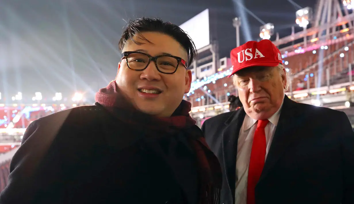 Dua pria berpakaian seperti pemimpin Korea Utara Kim Jong Un (kiri) dan Presiden AS, Donald Trump berpose bersama saat menghadiri upacara pembukaan Olimpiade Pyeongchang 2018 di Pyeongchang, Korea Selatan (9/2). (Jo Hyun-woo / Yonhap via AP)