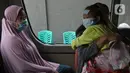 Warga berada di dalam mobil ambulans saat akan dibawa ke wisma atlet di Jalan As-Syafiiyah, Cipayung, Jakarta, Jumat (21/5/2021). Klaster Halal Bihalal di Cipayung bertambah 32 orang dari 51 orang menjadi 83 orang terpapar COVID-19 perhari ini. (Liputan6.com/Herman Zakharia)