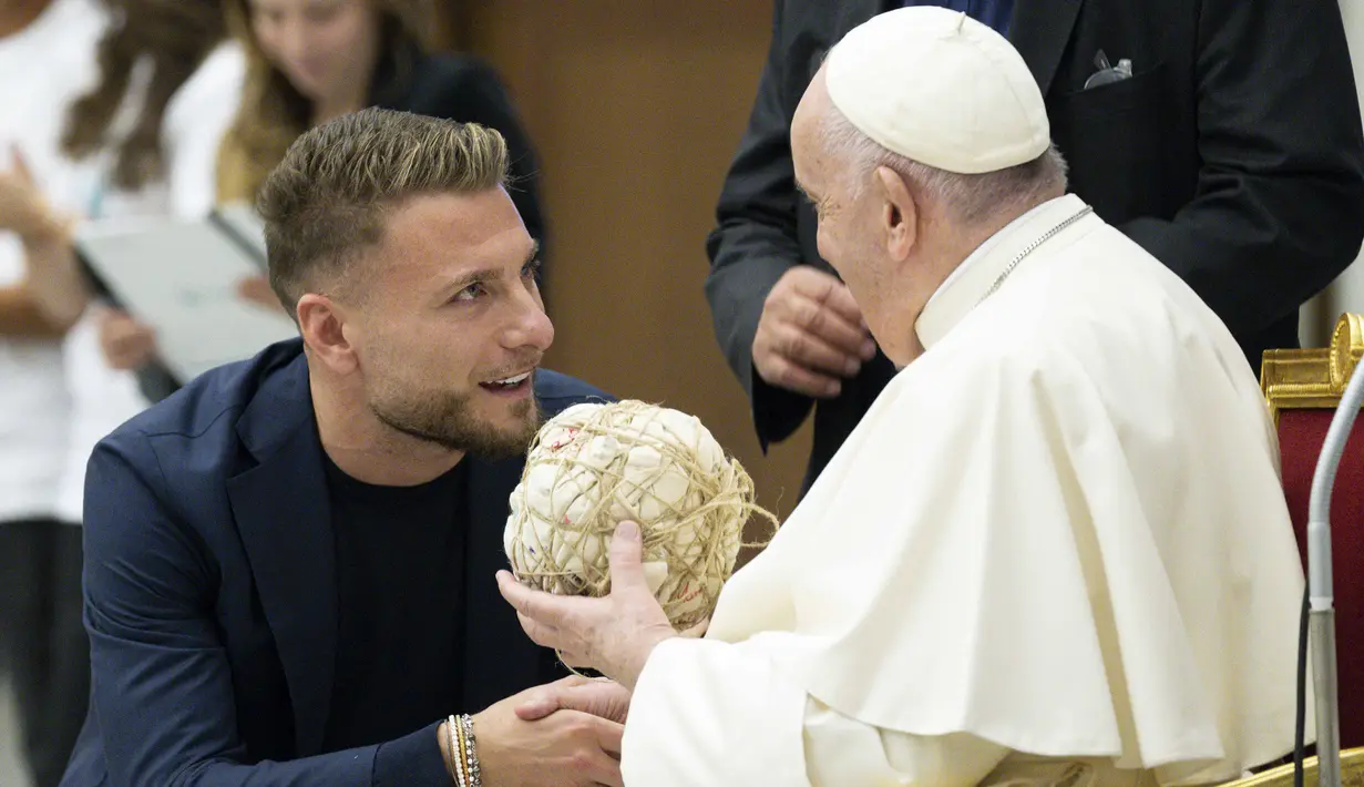 Pemain Lazio, Ciro (kiri) Immobile berbincang dengan Paus Fransiskus speaks with Pope Francis saat menghadiri audiensi dengan peserta pertandingan penghormatan "match for peace" untuk mengenang mendiang pemain Argentina, Diego Maradona, pada 14 November 2022 di aula Paul-VI, Vatikan. Pertandingan ini diselenggarakan oleh "WePlayForPeace", sebuah yayasan yang didirikan oleh Paus Fransiskus. (AFP/Vatican Media)