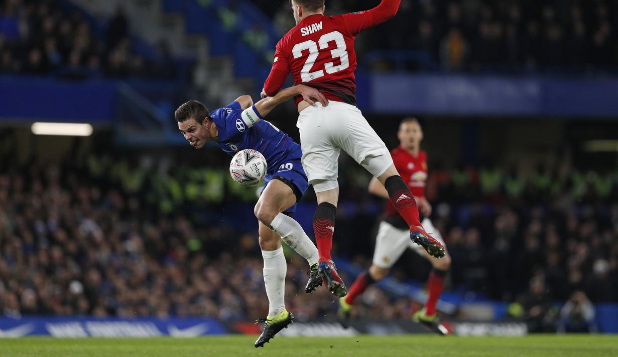 Duel yang dilakukan Cesar Azpilicueta dan Luke Shaw pada babak kelima FA Cup yang berlangsung di stadion Stamford Bridge, London, Selasa (19/2). Man United menang 2-0 atas Chelsea. (AFP/Adrian Dennis)