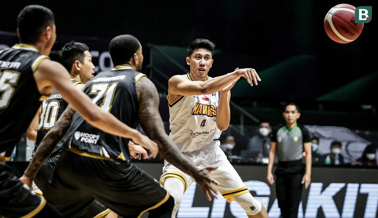 Pemain Tangerang Hawks Basketball Club, Ardian Ariadi (kanan) mengumpan bola saat laga lanjutan Seri 1 IBL 2022 melawan Dewa United Surabaya di Hall Basket GBK, Senayan, Kamis (20/01/2022). (Bola.com/Bagaskara Lazuardi)