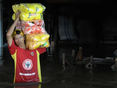 Intensitas curah hujan yang tinggi sejak Minggu (8/2) membuat Sungai Pesanggrahan meluap. Pedagang memindahkan barang dagangannya karena sebagian besar pertokoan dilanda banjir, Pasar Cipulir, Jakarta, Selasa (10/2/2015). (Liputan6.com/Andrian M Tunay)