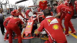 Tim mekanik Ferrari sibuk memperbaiki mobil Sebastian Vettel pada sesi latihan bebas F1 GP Singapura di Marina Bay City Circuit, (15/9/2017). (AP/Wong Maye-E)