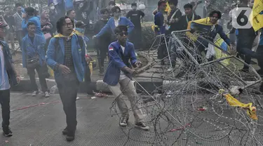 Mahasiswa berhasil menjebol kawat berduri yang dipasang polisi untuk menyekat aksi unjuk rasa atau demo BBM naik di kawasan Patung Kuda, Jakarta, Senin (5/9/2022). Ketegangan sempat terjadi antara massa dengan aparat. Lempar botol dan sejumlah benda dilakukan mahasiswa ke arah aparat. (Liputan6.com/Angga Yuniar)