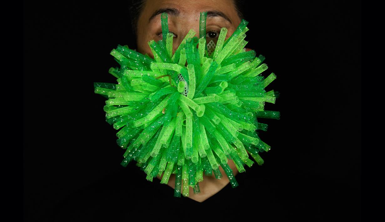 Edmond Kok, desainer dan aktor kostum teater Hong Kong, mengenakan topeng hijau runcing yang merupakan visualisasi 3D virus corona di Hong Kong pada 6 Agustus 2020. Edmond telah membuat lebih dari 170 masker yang terinspirasi oleh pandemi dan masalah politik Hong Kong. (AP Photo/Vincent Yu)