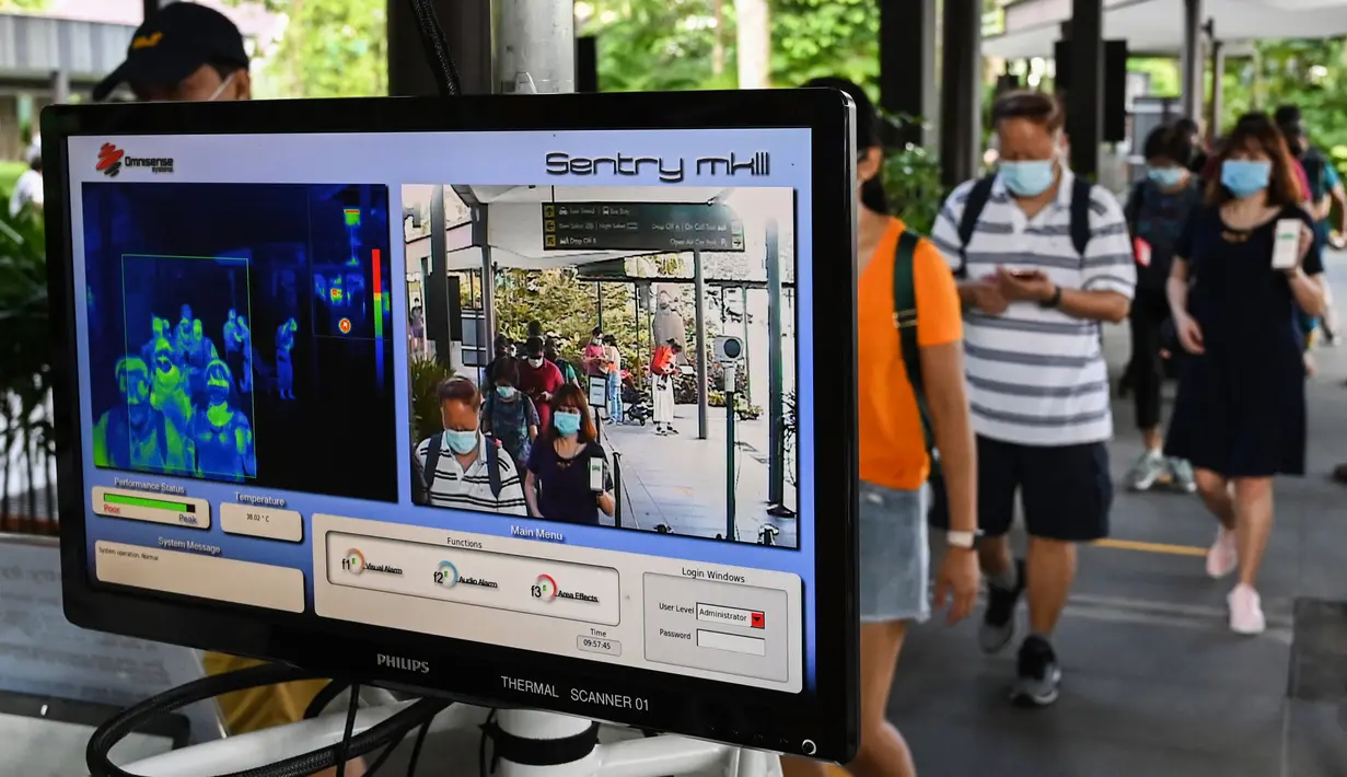 Pengunjung berjalan melalui area pemeriksaan suhu pada hari pertama pembukaan Kebun Binatang Singapura untuk umum di Singapura, Senin (6/7/2020). Kebun binatang yang hampir tiga bulan ditutup akibat pandemi virus corona ini dibuka kembali dengan penerapan protokol kesehatan. (Roslan RAHMAN/AFP)