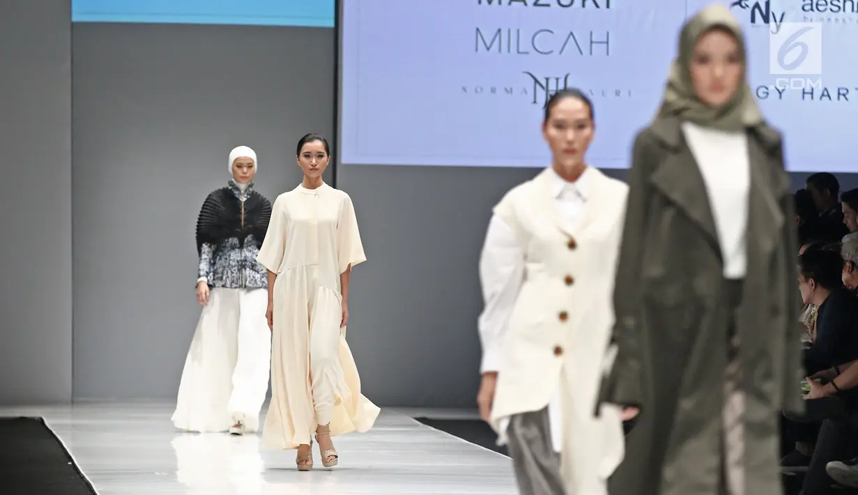 Sejumlah model berjalan diatas catwalk saat peragaan busana Jakarta Fashion Week 2018 di Senayan City, Jakarta, Sabtu (21/10). Memasuki tahun ke-10, JFW 2018 mengusung tema 'Bhinneka dan Berkarya'. (Liputan6.com/Herman Zakharia)