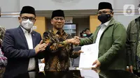 Menteri Agama Yaqut Cholil Qoumas (kanan) menerima dokumen Penetapan Biaya Penyelenggaraan Ibadah Haji Tahun 1443 H/2022 dari Ketua Komisi VIII DPR Yandri Susanto dalam rapat kerja dengan Komisi VIII DPR di Kompleks Parlemen, Senayan, Jakarta, Rabu (13/4/2022). (Liputan6.com/Angga Yuniar)