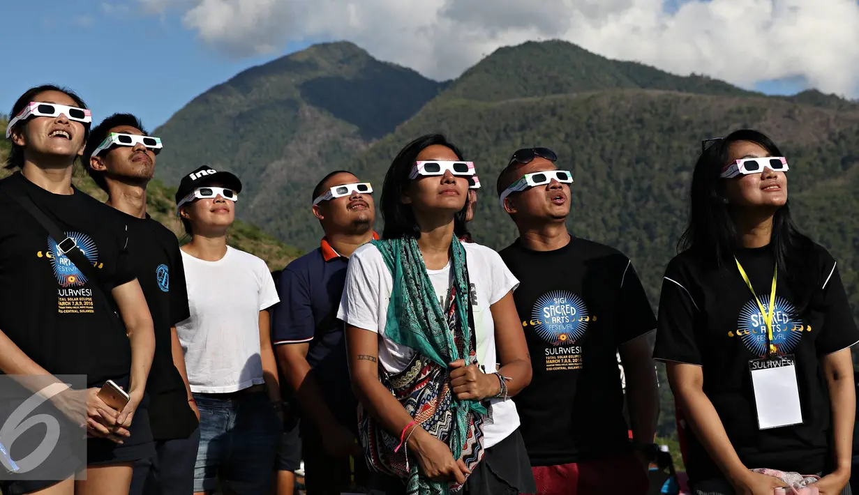 Wisatawan menyaksikan proses gerhana matahari total di Bukit Matantimali, Sigi, Sulawesi Tengah, Rabu (9/3). Fenomena alam yang terjadi setiap 350 tahun menjadi daya tarik bagi wisatawan lokal hingga mancanegara. (Liputan6.com/Immanuel Antonius)