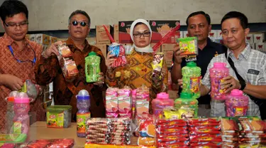 Kepala BPOM Penny K Lukito (tengah) menunjukkan barang bukti saat menggerebek pabrik makanan ringan ilegal atau palsu di Kota Tangerang, Kamis (4/8). Ada 7.000 kardus berhasil diamankan petugas dengan kerugian Rp 400 juta. (Liputan6.com/Gempur M Surya)