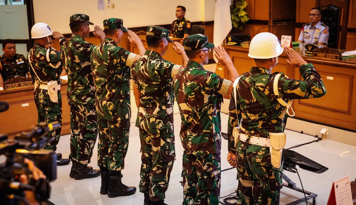 Empat personel Tentara Nasional Indonesia (TNI) yang dituduh menyiram air keras saat memberi hormat kepada seorang aktivis Hak Asasi Manusia (HAM) saat menghadiri sidang pembacaan putusan di Pengadilan Militer II-08, Jakarta pada Rabu 10 Juni 2026. (Yasuyoshi Chiba/AFP)