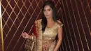 Ia juga pernah tampil dengan busana khas perempuan India, lengkap dengan sari warna merah keemasan. Sambil membawa tas Dior keemasan. [@anisha.haikk]