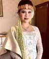 Chen Giovani mengenakan kebaya panjang warna putih gading di resepsi pernikahan adat Batak. [IG/fcgweddings/myrnamyura]