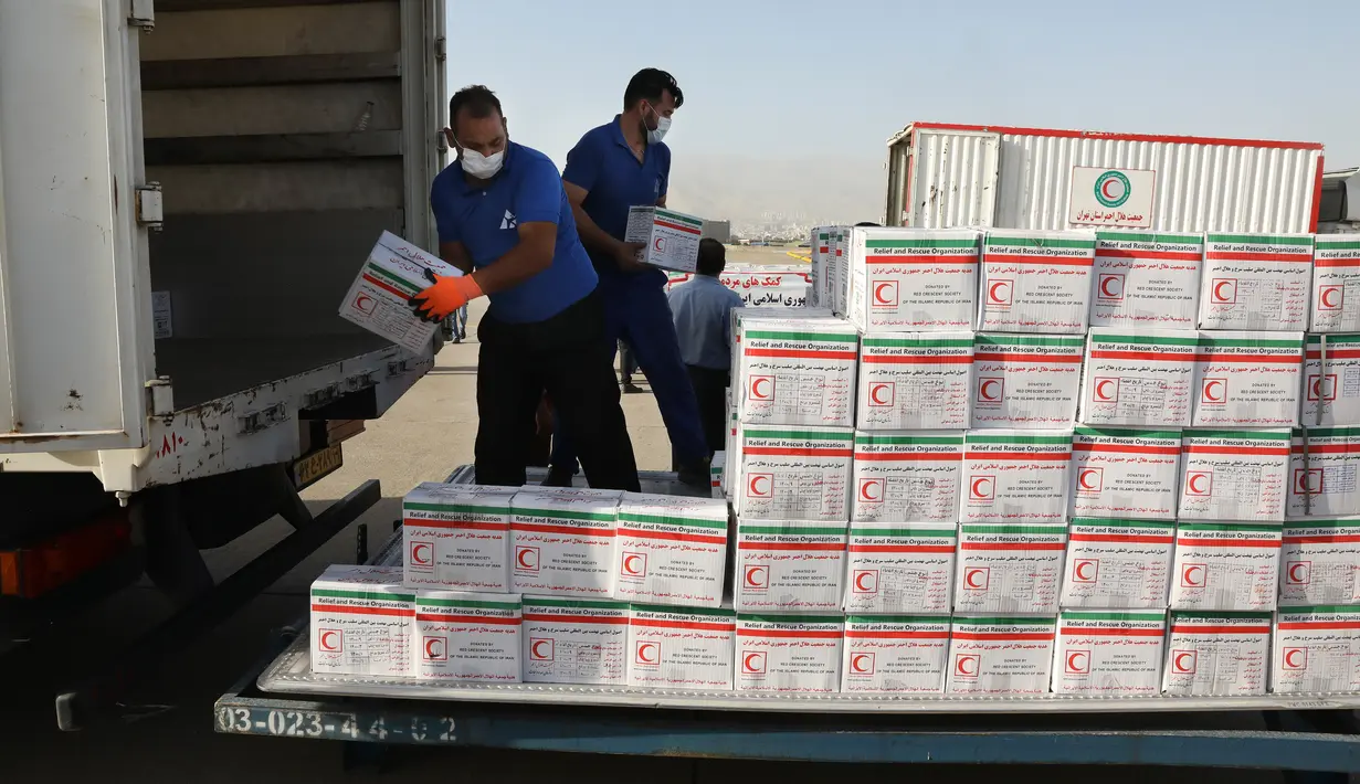 Pekerja membongkar kotak pasokan bantuan dari truk untuk dimuat ke pesawat menuju Beirut, Lebanon, di Bandara Mehrabad di Teheran, Rabu (5/8/2020). Iran mulai mengirimkan makanan, obat-obatan, dan peralatan medis ke Lebanon pascaledakan yang mengguncang pelabuhan di Beirut. (AP Photo/Vahid Salemi)
