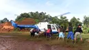 Warga gotong royong menurunkan barang dari helikopter PMI saat pendistribusian bantuan untuk korban banjir bandang dan longsor di Desa Cileuksa, Sukajaya, Bogor, Senin (6/1/2019). PMI mengerahkan helikopter lantaran lokasi bencana tidak bisa dijangkau melalui jalur darat. (Liputan6.com/Tim Media JK)
