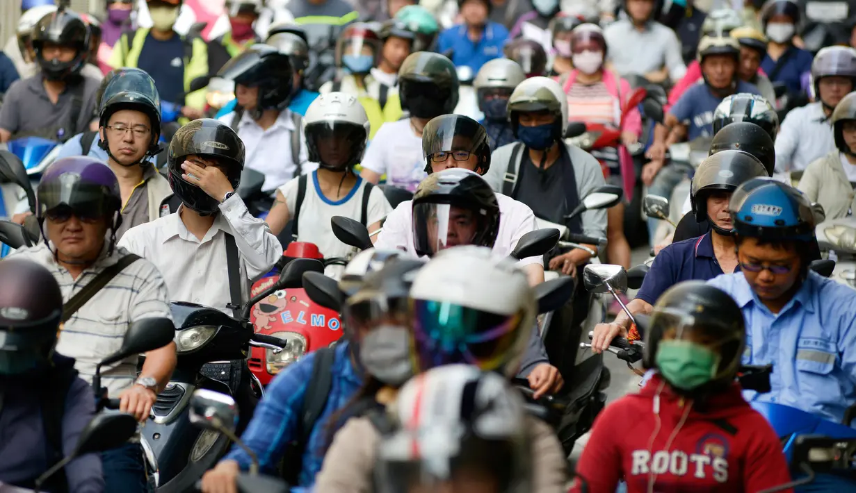 Sejumlah pengendara sepeda motor mengantre untuk melintas pada jam sibuk pagi hari di Jembatan Taipei, China (21/5). Uniknya, motor yang melintas mayoritas berjenis skuter matik. (AFP Photo/Chris Stowers)
