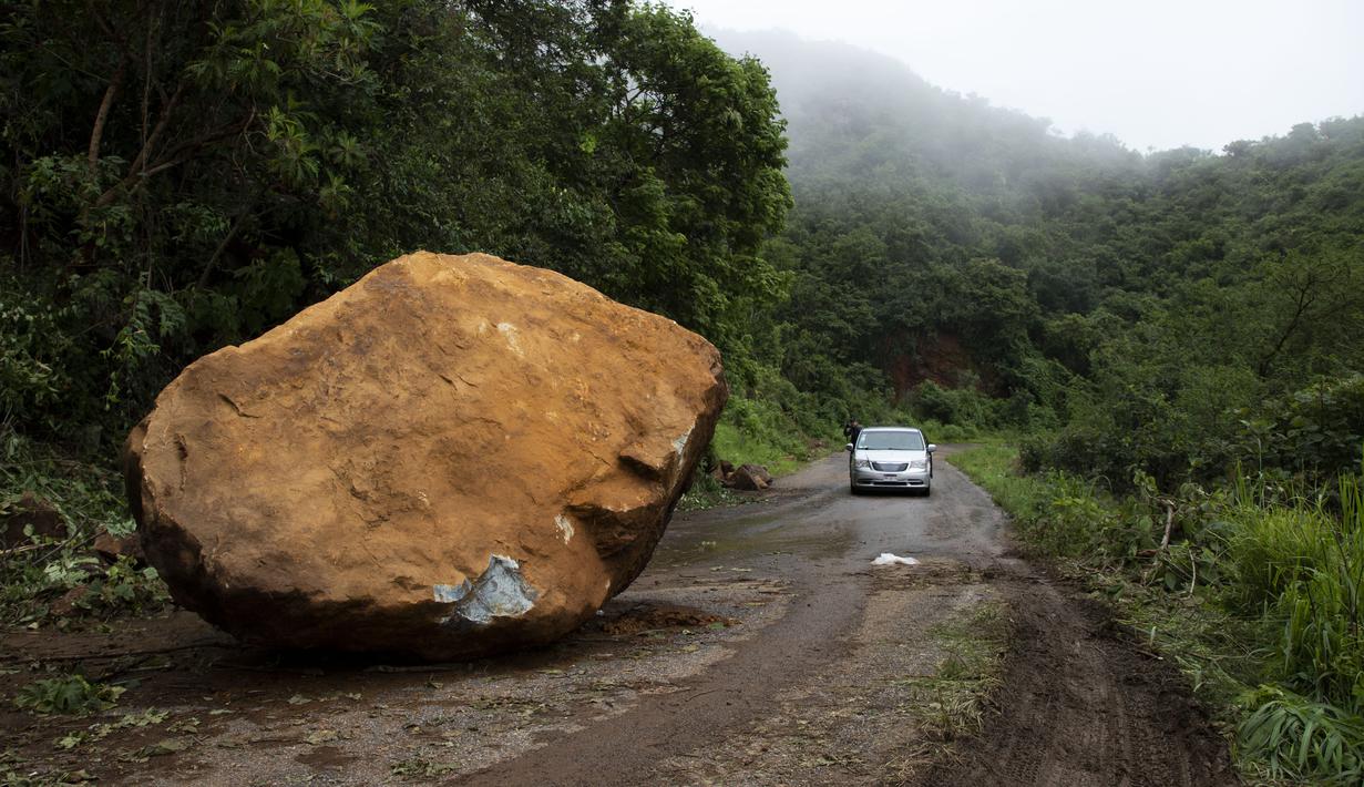 Sebuah batu besar terletak di jalan, sehari setelah gempa bumi di dekat Chinicuila, negara bagian Michoacan, Meksiko, Selasa (20/9/2022). Dua orang tewas dan puluhan bangunan rusak oleh gempa berkekuatan Magnitudo 7,6 yang mengguncang Meksiko pada peringatan dua gempa dahsyat, kata pihak berwenang Selasa. (AP Photo/Armando Solis)