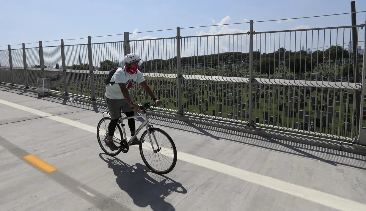 Pengendara sepeda melintasi jembatan di dekat sebuah taman pemakaman di New York, Amerika Serikat (AS) (29/7/2020). Kematian akibat COVID-19 di AS telah menembus angka 150.000 pada Rabu (29/7), tepatnya 150.034 hingga pukul 15.35 waktu setempat atau Kamis (30/7) pukul 02.35 WIB. (Xinhua/Wang Ying)