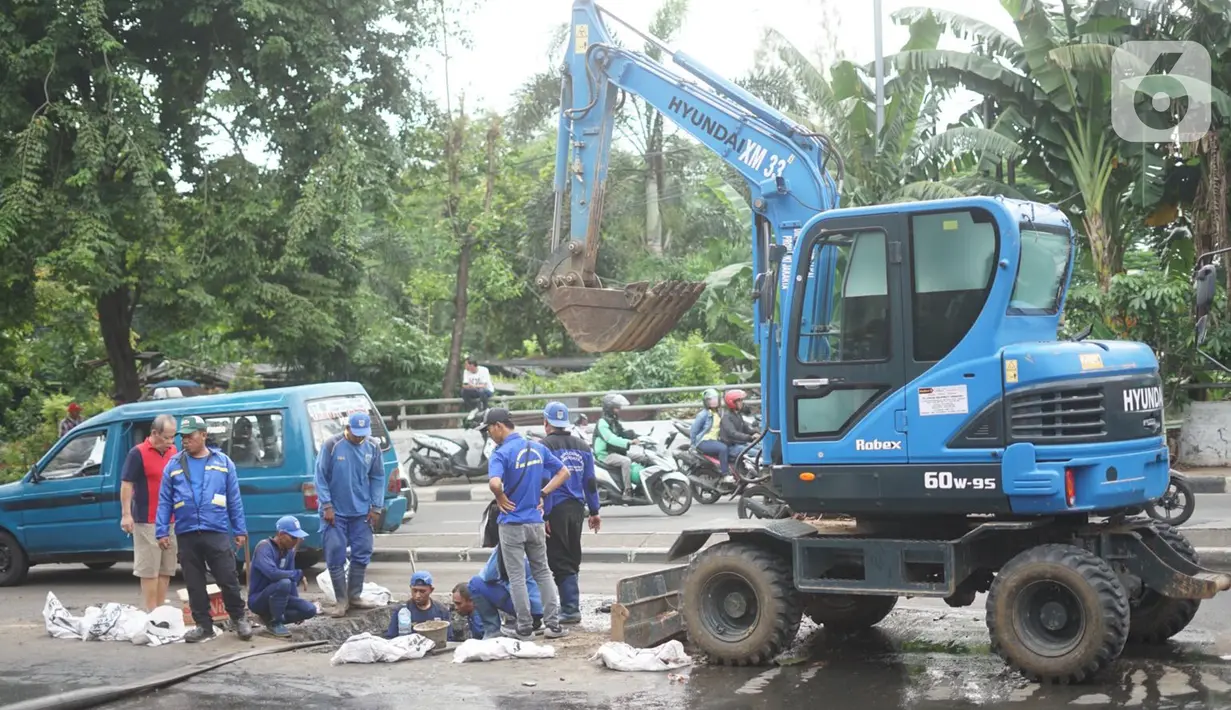 Petugas Sudin SDA Jakarta Timur dibantu alat berat membersihkan saluran gorong-gorong yang tertutup lumpur dan sampah di kawasan Pasar Rebo, Kamis (19/3/2020). Pembersihan untuk memperlancar sistem drainase yang tersumbat dan kerap menimbulkan genangan air. (Liputan6.com/Immanuel Antonius)