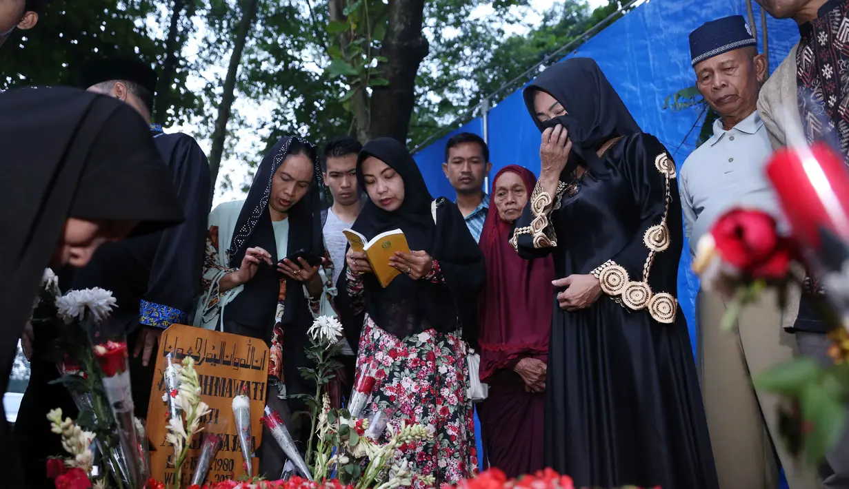 "Ada bapak ama emak. Dan keluarga pada ngumpul. Kirim Al Fatihah ya mbak Yuli," kata Sammy, bapak Jupe menyapa makam anaknya di TPU Pondok Ranggon, Jakarta Timur, Selasa (13/6). (Nurwahyunan/Bintang.com)