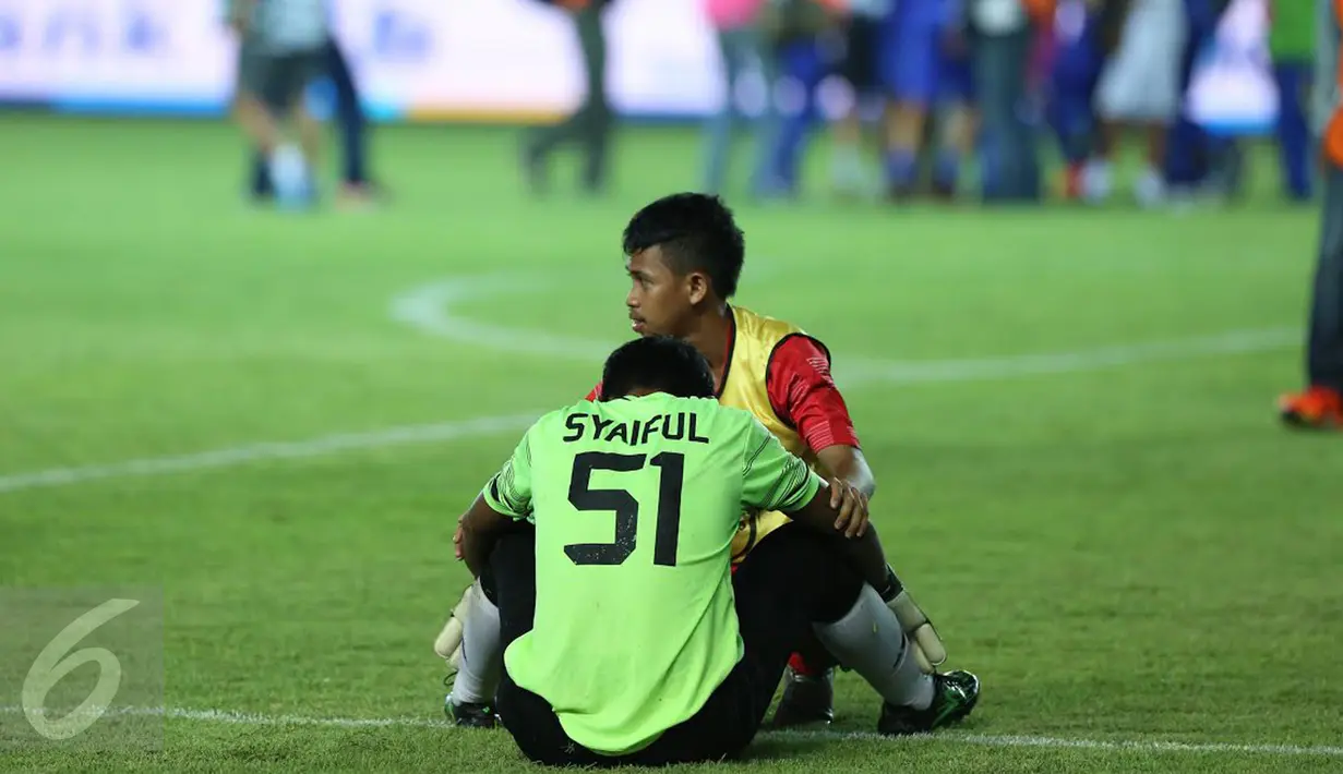 Penjaga gawang Sulawesi Selatan, Syaiful ditenangkan rekan setimnya usai dikalahkan Jawa Barat di laga final PON XIX 2016 di Stadion Si Jalak Harupat, Kab Bandung, Rabu (28/9). Sulsel kalah adu penalti 5-4. (Liputan6.com/Helmi Fithriansyah)