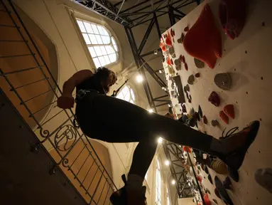 Seorang peserta berlatih memanjat di lokasi Climbing District di Paris, Rabu, 11 Januari 2023. Tembok panjat buatan baru ini dibuka pada November 2022 di dalam bekas kapel abad ke-19, bernama le couvent des Oblats de Marie-Immaculee. (AP Photo/Christophe Ena)