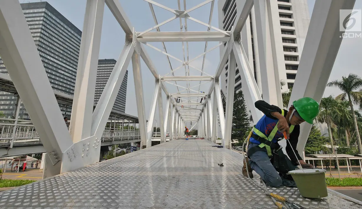 Pekerja melakukan pengecatan di Jembatan Penyebrangan Orang (JPO) Dukuh Atas, Jakarta, Rabu (3/10). Rencananya Pemprov DKI Jakarta akan merelokasi JPO Dukuh Atas namun belum dapat dipastikan kapan dilaksanakan. (Liputan6.com/Herman Zakharia)