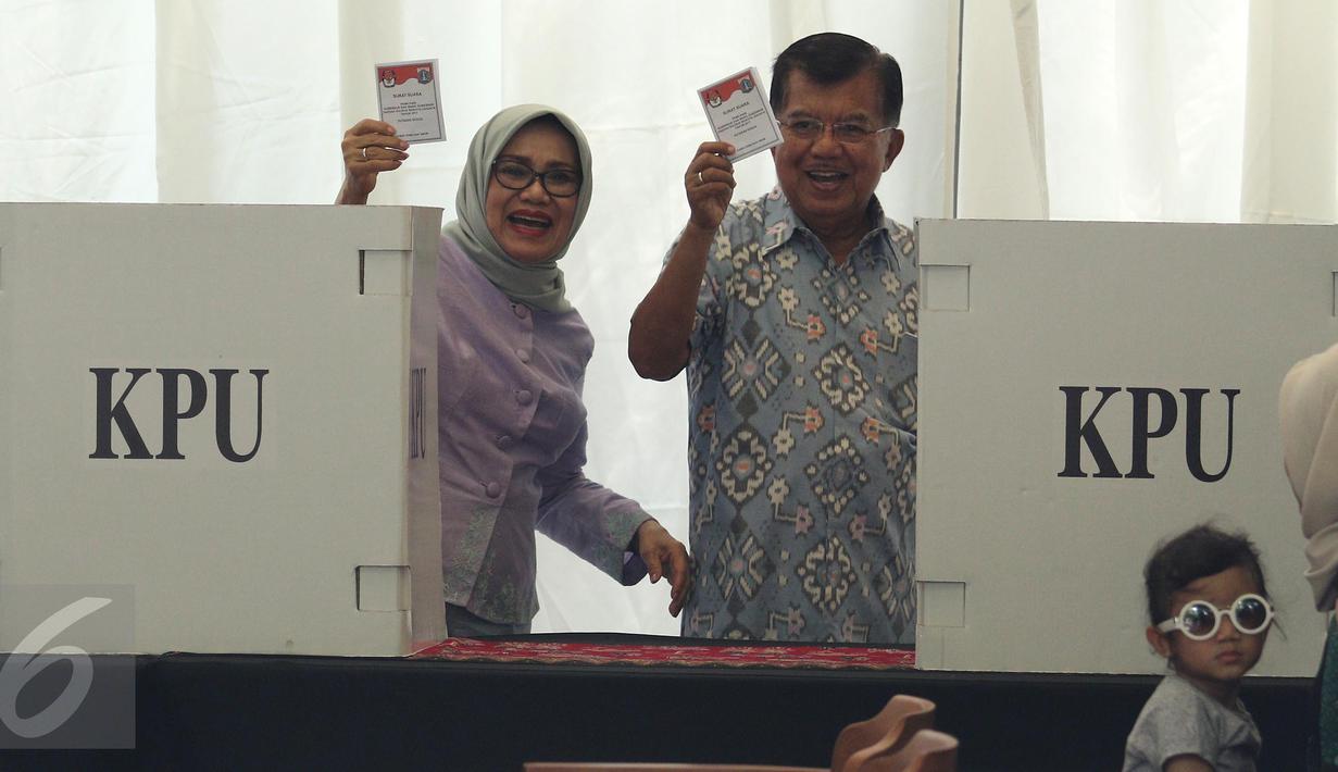 Wapres Jusuf Kalla (JK) bersama istri, Mufidah Kalla, menunjukkan surat suara di TPS 03 Kelurahan Pulo, Jakarta Selatan, Rabu (19/4). Di TPS bernuansa Betawi itu, JK memberikan suaranya pada Pilkada DKI putaran kedua. (Liputan6.com/Herman Zakharia)
