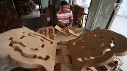 Pekerja menghaluskan kayu yang akan dibuat rekal Al Quran atau tatakan untuk Al Quran di kawasan Klender, Jakarta, Senin (5/6). Rekal Al Quran ini dijual dengan kisaran harga Rp20 ribu sampai Rp200 ribu. (Liputan6.com/Angga Yuniar)