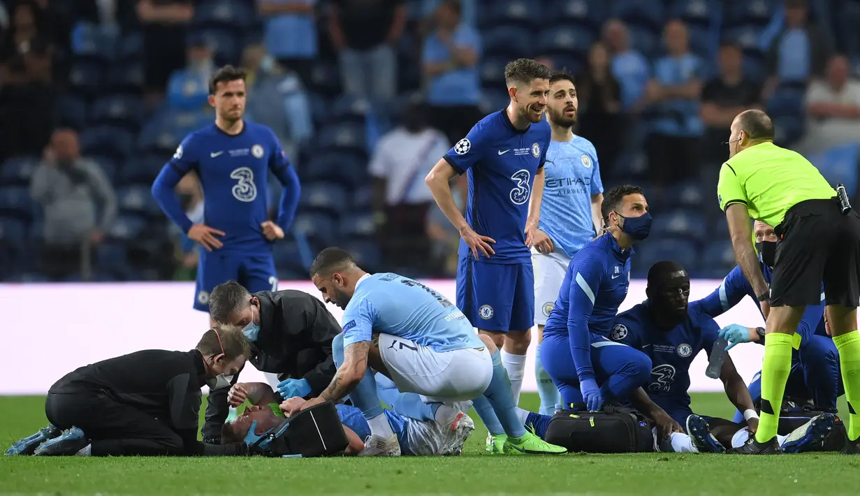 Kevin De Bruyne (ke-2-kiri) mendapat perawatan medis setelah bertabrakan dengan Antonio Rudiger selama pertandingan final Liga Champions antara Manchester City dan Chelsea di Stadion Dragao di Porto, Portugal, Sabtu (29/05/2021) atau Minggu dini hari WIB. (Foto: AFP/Pool/David Ramos)