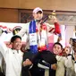 Peraih medali emas Olimpiade Paris 2024 cabang angkat besi nomor 73kg Rizki Juniansyah diangkat oleh teman-temannya sesama lifter usai tiba di Bandara Internasional Soekarno-Hatta, Tangerang, Selasa (13/8/2024). (Abdul Aziz/Bola.com).