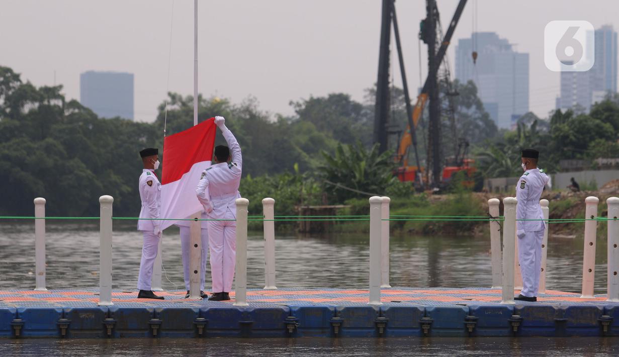 Anggota Paskibraka melakukan pengibaran bendera merah putih di Sungai Cisadane, Kota Tangerang, Banten, Kamis (28/10/2021). Pengibaran bendera merah putih yang di ikuti puluhan pemuda tersebut di lakukan untuk memperingati hari sumpah pemuda. (Liputan6.com/Angga Yuniar)