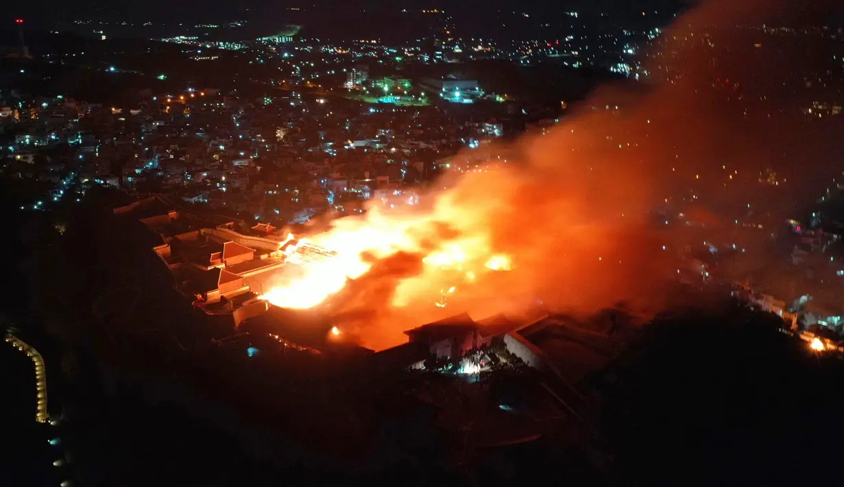 Kobaran api dan asap terlihat saat kebakaran Kastil Shuri di Okinawa, Jepang selatan, Kamis (31/10/2019). Sekitar 20 unit kendaraan pemadam kebakaran dan lebih dari 50 petugas pemadam kebakaran dikerahkan untuk memadamkan api. (Jun Hirata/Kyodo News via AP)