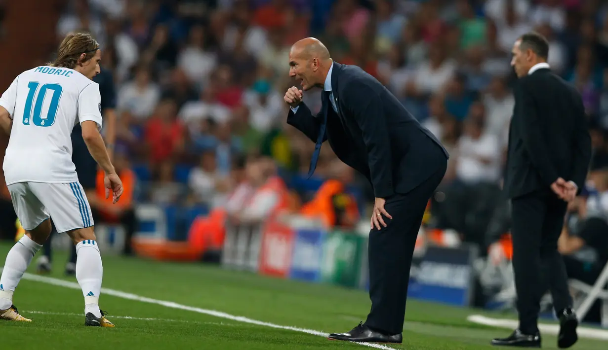 Pelatih Real Madrid Zinedine Zidane berbicara dengan gelandang Luka Modric saat bertanding pada penyisihan Grup H Liga Champions di stadion Santiago Bernabeu, Spanyol, (13/9). Madrid menang telak 3-0 atas APOEL. (AP Photo/Francisco Seco)