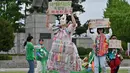 Aktivis lingkungan yang mengenakan pakaian berbahan sampah plastik tampil dalam acara kampanye memperingati Hari Bumi internasional di Seoul, Korea Selatan, Senin (22/4/2024). (Jung Yeon-je / AFP)