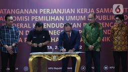 Sekretaris Jenderal KPU RI Bernad Dermawan Sutrisno (kedua kiri), Dirjen Dukcapil Zudan Arif Fakrulloh (tengah), dan Ketua KPU RI Hasyim Asy'ari (kedua kanan) saat penandatanganan perjanjian kerja sama antara Direktur Jenderal Dukcapil Kemendagri dengan Sekretaris Jenderal KPU RI di Gedung KPU, Jakarta, Rabu (29/6/2022). Kerja sama ini mengenai pemanfaatan nomor induk kependudukan, data kependudukan, dan kartu tanda penduduk elektronik dalam pemutakhiran data pemilih. (Liputan6.com/Angga Yuniar)