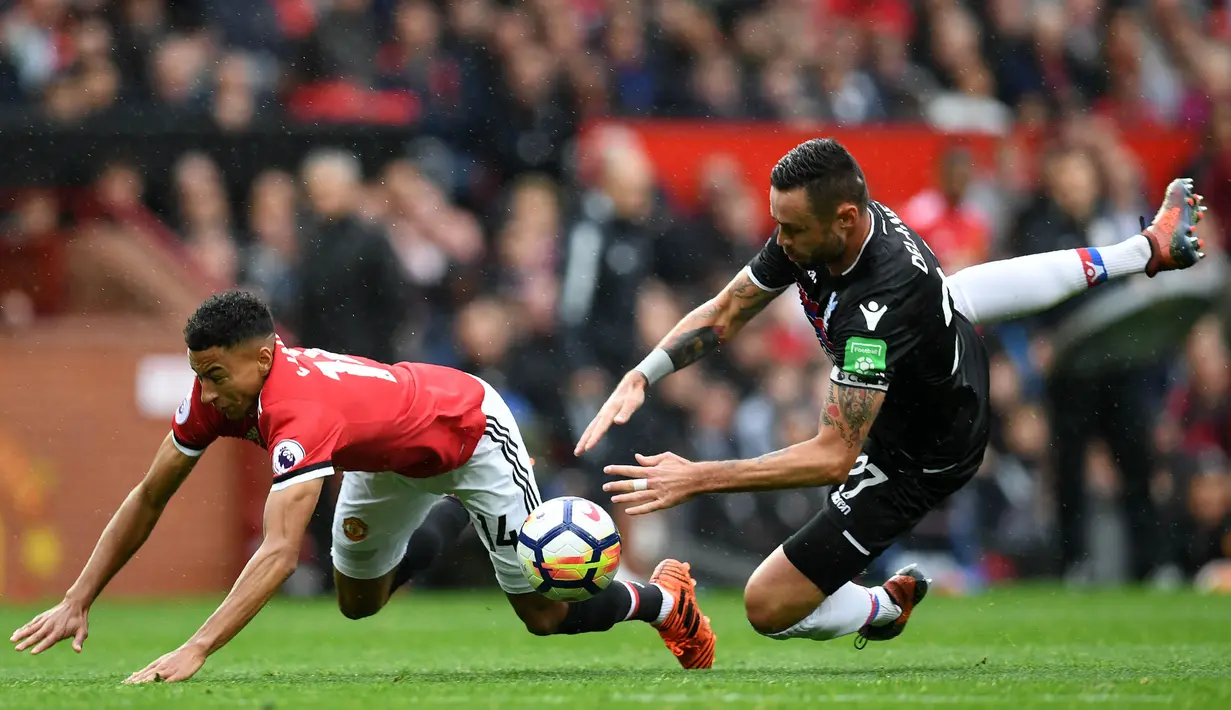 Gelandang Manchester United, Jesse Lingard, dijatuhkan bek Crystal Palace, Damien Delaney, pada laga Premier League di Stadion Old Trafford, Manchester, Sabtu (30/9/2017). MU menang 4-0 atas Palace. (AFP/Paul Ellis)
