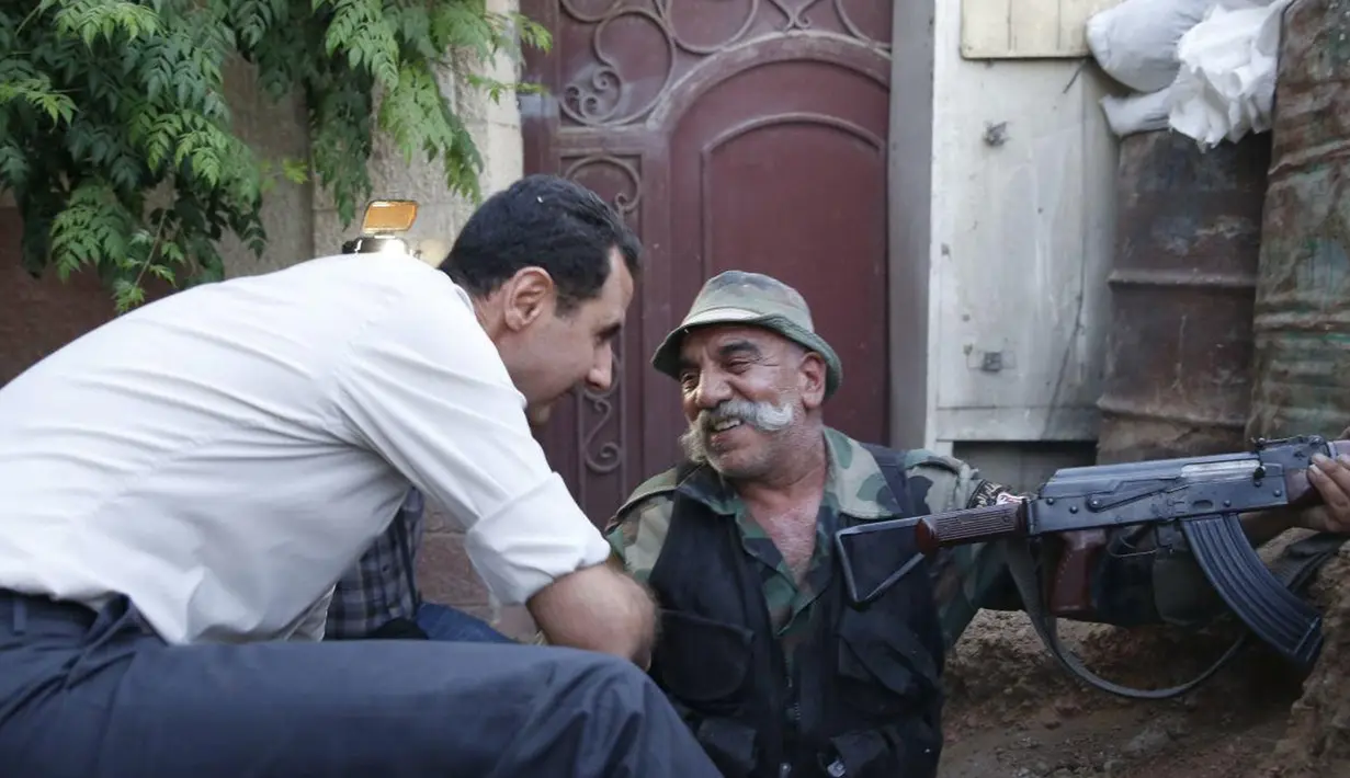 Presiden Suriah Bashar al-Assad Assad mendatangi langsung tentara Suriah yang berada di garda terdepan bersama di Desa Marj al-Sultan, timur Ghouta, Damaskus, untuk melawan aksi terorisme, Suriah, Minggu (26/6).(REUTERS/Sana)