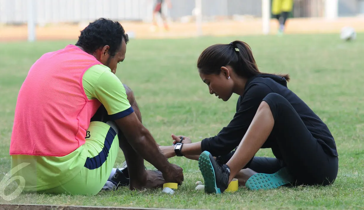 Pemain belakang Persipasi Bandung Raya (PBR), Leonard Tupamahu (kiri) mendapat perawatan Adinda Pricilla (Fisioterapis PBR) jelang laga melawan Bekasi Putra di Stadion Patriot, Bekasi, Selasa (25/8/2015). (Liputan6.com/Helmi Fithriansyah) 