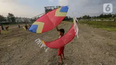 Seorang anak bersiap menerbangkan layangan koang di lahan kosong Kampung Sawah, Ciputat, Tangerang Selatan, Selasa (2/6/2020). Masa pembatasan sosial berskala besar selama pandemi Covid-19 tidak menyurutkan anak-anak bermain layangan koang meski tanpa menggunakan masker. (Liputan6.com/Fery Pradolo)