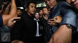 Tampak pengawal ketat cawagub nomor satu Sylviana Murni usai diperiksanya Bareskrim di Gedung Ombudsman, Jakarta, Senin (30/1).  Sylviana Murni, diperiksa polisi terkait dugaan korupsi pembangunan Masjid Al Fauz. (Liputan6.com/Faizal Fanani)