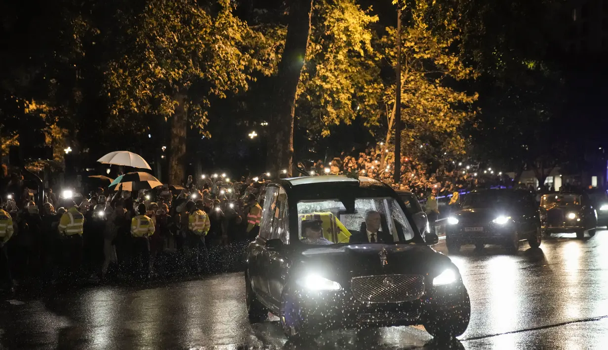 Mobil jenazah  yang membawa peti mati Ratu Elizabeth II menuju ke Istana Buckingham di London, Selasa, 13 September 2022. Ratu Elizabeth II, raja terlama yang memerintah Inggris dan batu stabilitas di sebagian besar abad yang bergejolak, meninggal Kamis 8 September 2022, setelah 70 tahun bertahta, pada usia 96 tahun. (AP Photo/Andreea Alexandru)