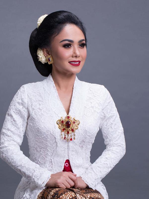 Yuni Shara tampil dalam balutan kebaya bernuansa putih. Untuk melengkapi penampilannya itu, Yuni juga menyematkan sebuah bros dengan paduan warna merah dan gold. (Liputan6.com/IG/@yunishara36)