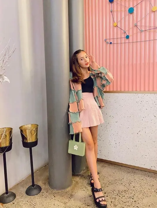 Tampilan feminin lainnya yang bisa kamu tiru adalah OOTD Beby Tsabina satu ini. Padukan colour blocks cardigan nuansa warna peach-tosca dengan tanktop dan mini skirt warna pink. Manis banget! (Instagram/bebytsabina).