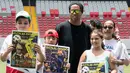 Mantan bintang sepak bola Brasil Ronaldinho berpose dengan anak-anak Kosta Rika sebelum pertandingan persahabatan melawan mantan pemain Kosta Rika di Stadion Nasional di San Jose, (4/8). (AFP Photo/Ezequiel Becerra)