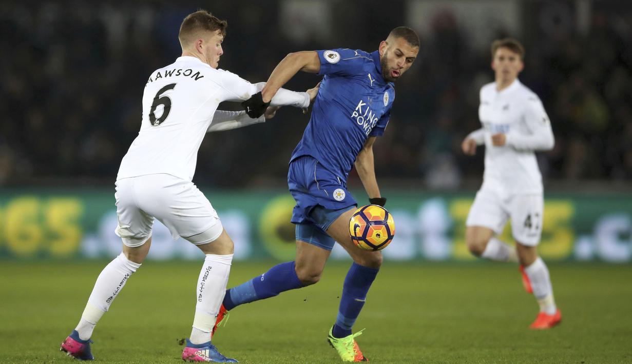 Pemain Swansea City, Alfie Mawson (kiri) berebut bola dengan pemain Leicester City, Islam Slimani pada lanjutan Premier League di Liberty Stadium, Swansea, Wales,  (12/2/2017). Swansea menang 2-0. (Nick Potts/PA via AP)