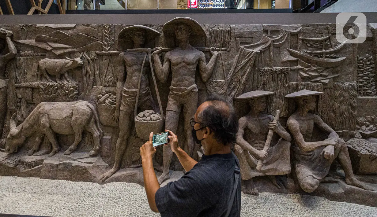Pengunjung melihat relief peninggalan Bung Karno di pusat perbelanjaan Sarinah di Jakarta, Senin (21/3/2022). Relief bersejarah peninggalan Presiden pertama RI, IR Soekarno tersebut ditemukan di Basement Gedung Sarinah saat pemugaran pada awal Januari 2021 lalu. (Liputan6.com/Faizal Fanani)