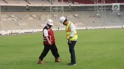 Menpora Imam Nahrawi (kanan) melihat rumput lapangan saat meninjau perkembangan renovasi Stadion Utama Gelora Bung Karno, Jakarta, Selasa (8/8). Saat ini, renovasi telah mencapai 80% dan ditargetkan rampung akhir 2017. (Liputan6.com/Helmi Fithriansyah)