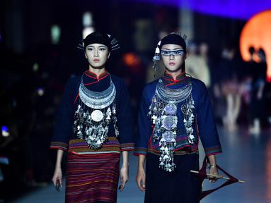 Dua model memeragakan kreasi busana yang terbuat dari brokat Li, pakaian tradisional yang dibuat oleh kelompok etnis Li, dalam sebuah peragaan busana di Haikou, Provinsi Hainan, China selatan, pada 19 November 2020. (Xinhua/Guo Cheng)